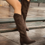 bottes western santiags femme marron portées assise sur un banc avec look denim